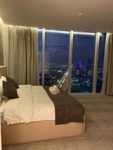 een slaapkamer met een groot bed en een groot raam bij Raffal Tower Apartment in Riyad