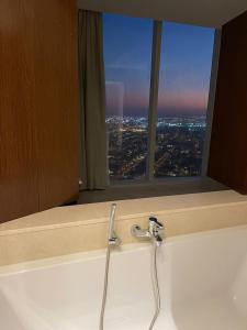 lavabo en el baño con vistas a la ciudad desde una ventana en Raffal Tower Apartment, en Riad