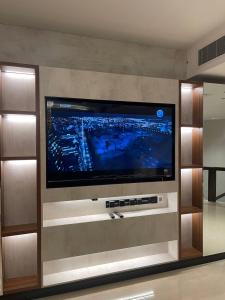 TV de pantalla plana grande en la pared en Raffal Tower Apartment, en Riad