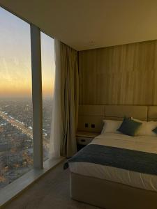 a bedroom with a bed and a large window at Raffal Tower Apartment in Riyadh