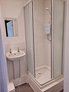 a bathroom with a shower and a sink at The Sanderling in Morecambe