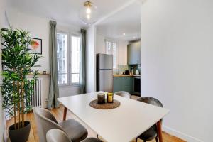 a kitchen and dining room with a white table and chairs at Agréable 2 pièces très bien situé in Boulogne-Billancourt