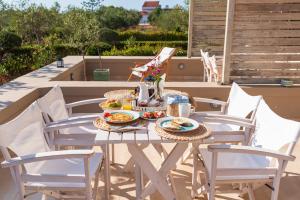 a table with plates of food on a patio at Aelia Home Suites in Marathopolis