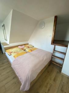 ein kleines Bett in einem Zimmer mit einer Leiter in der Unterkunft Privát u Zdenky in Tvrdošín