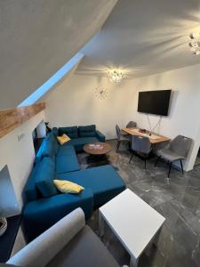 ein Wohnzimmer mit einem blauen Sofa und einem TV in der Unterkunft Privát u Zdenky in Tvrdošín