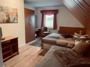 a bedroom with two beds and a desk and a desk at Pension Buschmühle in Ohorn