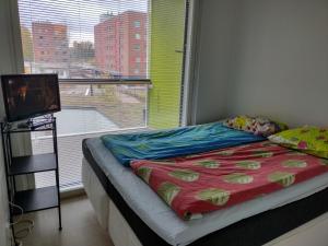 a bed sitting in a room with a window at Helsinki Private-Yksityinen-Частный Room in Shared Apartment into Airport-BusTrain Station-University in Helsinki