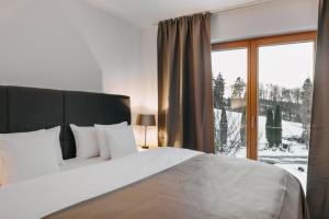 a bedroom with a large bed and a large window at Apartments Mika Hof in Weitnau