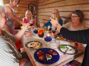 un gruppo di persone sedute intorno a un tavolo a bere vino di Stabburet, Lensmannsgården a Namsos