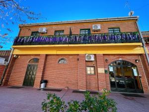 um edifício de tijolos com uma varanda em cima em Hostel Napoles em Madrid