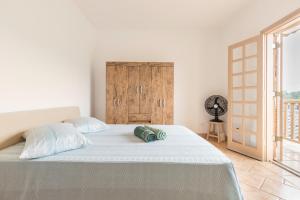 1 dormitorio con 1 cama blanca grande y puerta de madera en Casa de Campo Piscina Aquecida Atibaia, en Atibaia 162 fotos más
