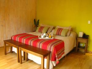a bedroom with a bed with a tray ofiments on it at Mocona Virgin Lodge in Moconá Falls