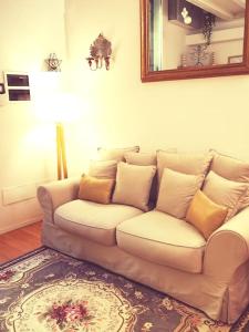 um sofá branco numa sala de estar com um espelho em Bologna Boutique Home em Bolonha