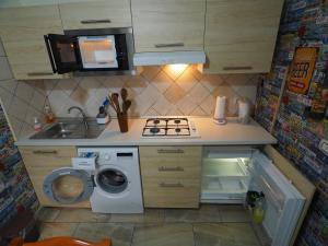 a small kitchen with a stove and a washing machine at Domus Toledo in Naples