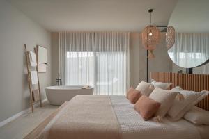 1 dormitorio con 1 cama grande y bañera en Salobre Oasis Suites en Salobre