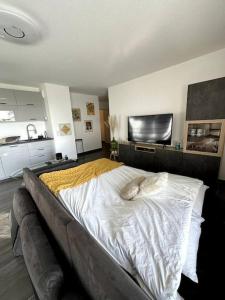 1 dormitorio con 1 cama grande con sábanas blancas en Superbe appartement proche de Strasbourg, en Bischheim