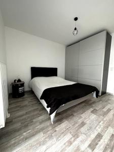 1 dormitorio con 1 cama y suelo de madera en Superbe appartement proche de Strasbourg, en Bischheim