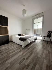 1 dormitorio blanco con 1 cama y suelo de madera en Superbe appartement proche de Strasbourg, en Bischheim