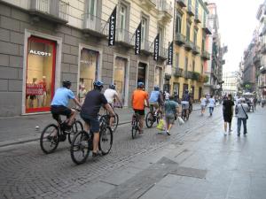 a group of people riding bikes down a street at Domus Toledo in Naples