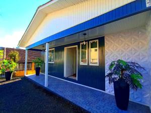 a blue and white house with a potted plant at Pousada Caminho do Altos in Bom Jardim da Serra