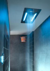 a bathroom with blue lights on a tiled wall at Il Castelluccio Country Resort Restaurant & SPA in Barberino di Mugello