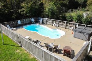 a backyard with a swimming pool and chairs and a fence at Golden Week CV6 in Corolla