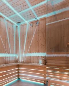 uma sauna com painéis de madeira e luzes azuis em Il Castelluccio Country Resort Restaurant & SPA em Barberino di Mugello