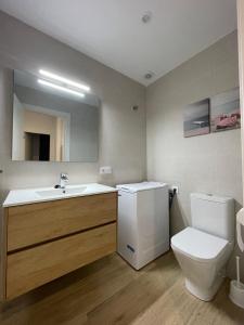 a bathroom with a sink and a toilet and a mirror at APCOSTAS - Marino Las Fuentes Superior in Alcossebre