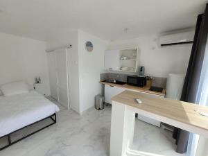 Jest to niewielki, biały pokój z łóżkiem i biurkiem. w obiekcie logement indépendant avec terrasse "Les Mésanges" w mieście Juvignac +22 zdjęcia