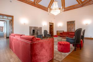Elle comprend un salon doté d'un mobilier rouge et d'une cheminée. dans l'établissement Palacio São Silvestre-Boutique Hotel, à Coimbra
