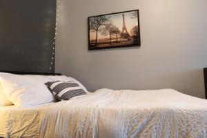 1 dormitorio con 1 cama con una foto de la torre Eiffel en Cozy Home in Downtown Winnipeg en Winnipeg