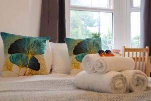 uma cama com toalhas e almofadas e uma janela em Heathrow Airport Studios with En-Suite em Southall