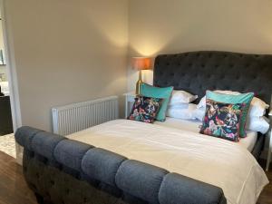 a bed with a blue headboard and pillows on it at Clara Lodge in Sallins