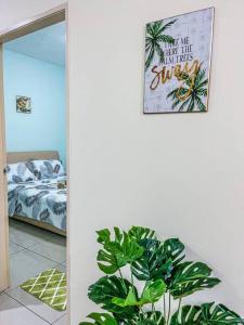 een kamer met een plant, een spiegel en een bed bij Cybercity Ph1 near KKIA by Family Homestay in Donggongon