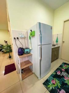 a kitchen with a white refrigerator in a room at Cybercity Ph1 near KKIA by Family Homestay in Donggongon