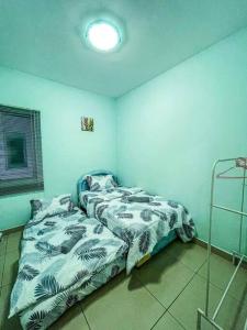 two beds in a room with blue walls at Cybercity Ph1 near KKIA by Family Homestay in Donggongon