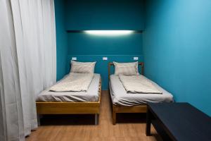 - 2 lits dans une chambre avec un mur bleu dans l'établissement 日月彩舟 日月潭背包客旅店 Sun Moon Lake Rainbow SUP Hostel, à Yuchi