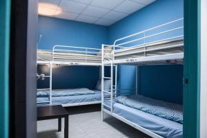 2 Etagenbetten in einem Zimmer mit blauen Wänden in der Unterkunft 日月彩舟 日月潭背包客旅店 Sun Moon Lake Rainbow SUP Hostel in Yuchi