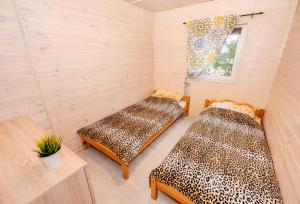 two beds in a room with a leopard print at Domki Przyjazna Osada in Darłowo