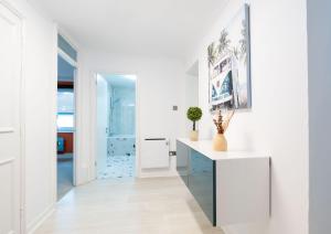 um corredor branco com um balcão branco e uma porta em Southsea Luxury Apartment em Portsmouth