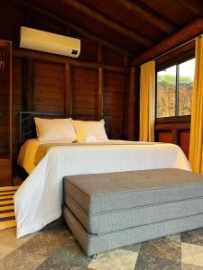 1 dormitorio con 2 camas y ventana en Pousada Vale Das Águias, en Jaguaruna