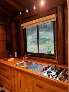 eine Küche mit einem Waschbecken und einem Fenster in der Unterkunft Pousada Vale Das Águias in Jaguaruna