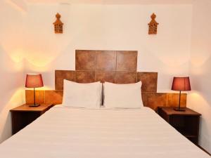 a bedroom with a large bed with two lamps at Casa da Mae in Salir
