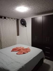 Un dormitorio con una cama con una bata naranja. en Alex home west cali, en Cali