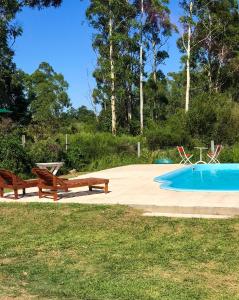 uma piscina com dois bancos e uma mesa de piquenique ao lado em Campo Verde em Concordia