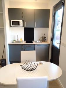 a kitchen with a white table and a microwave at Studio avec jardin clos et wifi a Rennes in Rennes
