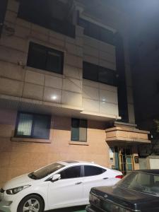 a white car parked in front of a building at Dongdaemun Studio in Seoul