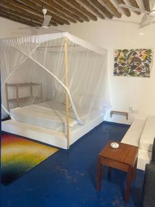 a bedroom with a bed and a table in a room at Babalao Rooftop Hotel in Paje