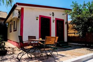 a table and chairs in front of a house at Studio Bucuria Corbu in Corbu