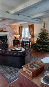 ein Wohnzimmer mit einem Weihnachtsbaum und einer Couch in der Unterkunft Chambres d'hôtes - Au Clos d'Amande in Lasne
